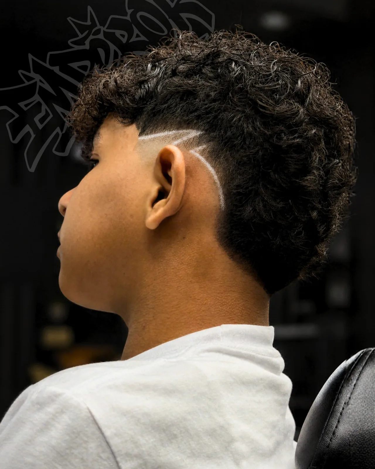 Corte con rizos y diseño de líneas a navaja