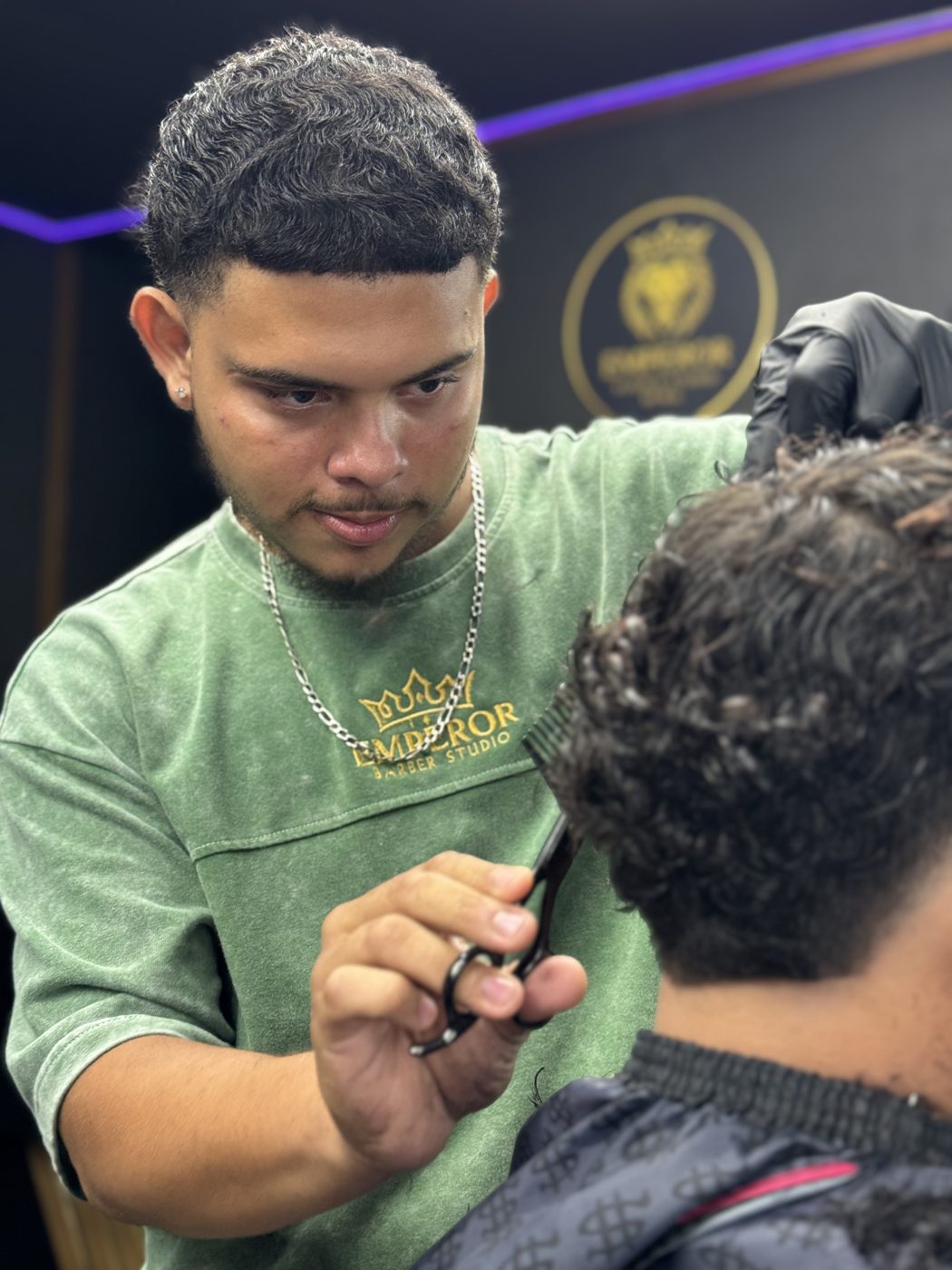 Barbero de Emperor cortando con tijera